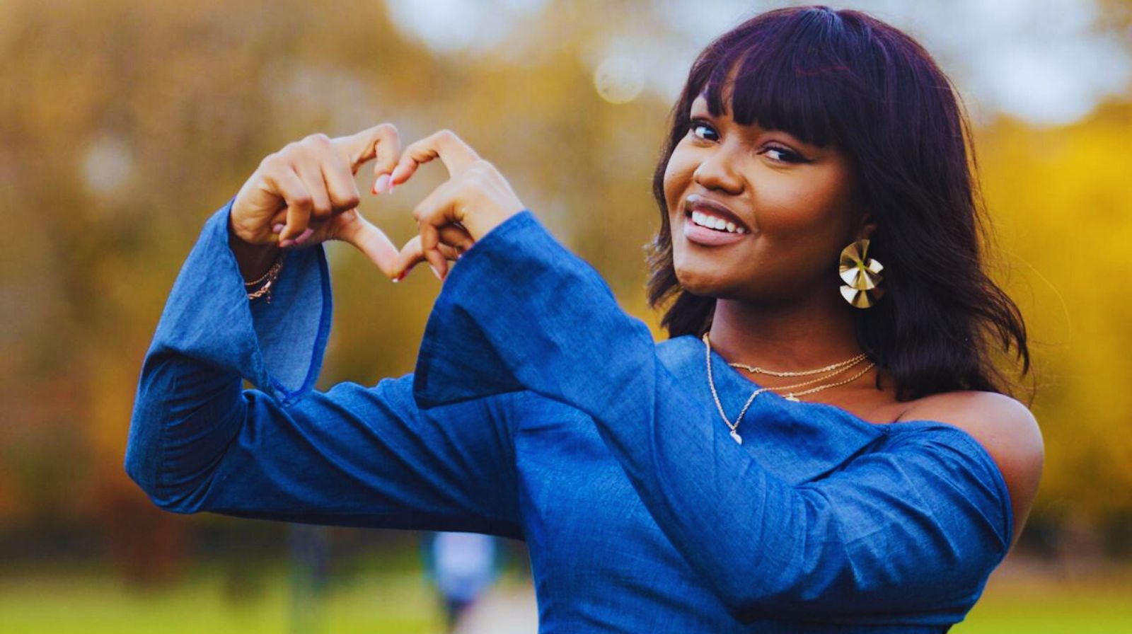 Happy young woman with heart hands